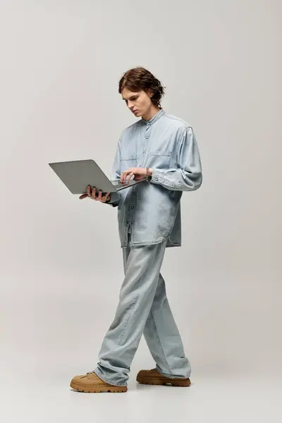 Man in fashionable attire interacts with a laptop, immersed in thoughtful concentration. — Stock Photo