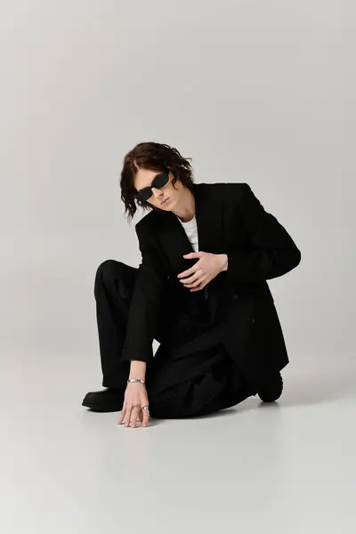 A handsome young man showcases his fashion sense with a sleek outfit set against a clean background. — Stock Photo