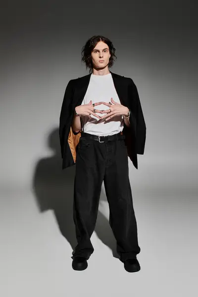 Handsome young man exudes confidence while posing in a chic outfit with a minimalist design. — Stock Photo