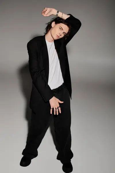 A handsome young man showcases his stylish outfit with an expressive pose in a chic indoor setting. — Stock Photo