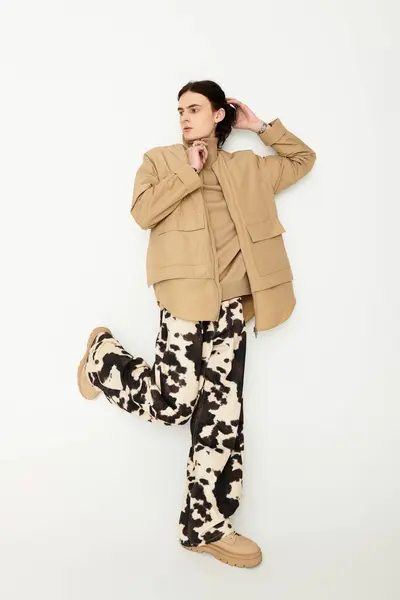 A stylish young man poses confidently in a striking mix of textures and patterns. — Stock Photo