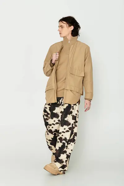 Giovane alla moda cammina con fiducia, mostrando abiti unici in un ambiente minimalista. — Foto stock