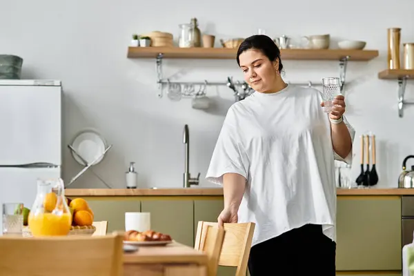 A beautiful young plus sized woman enjoys preparing a delightful breakfast in a stylish kitchen. — Stock Photo