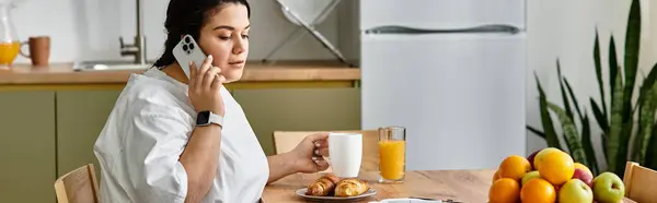 A young plus sized woman enjoys coffee and pastries during a bright morning call. — Stock Photo