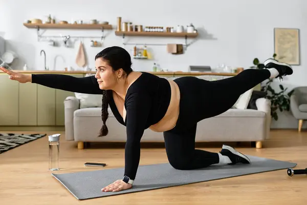 Engaging in a yoga pose, the young plus sized woman radiates strength and focus in her earthy space. — Stock Photo