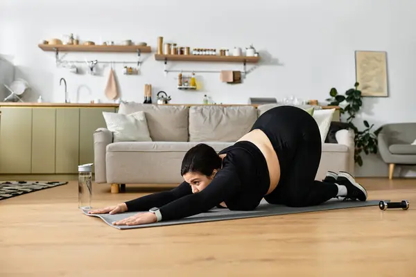 A plus sized woman practices yoga in a cozy living space, prioritizing her well being. — Stock Photo