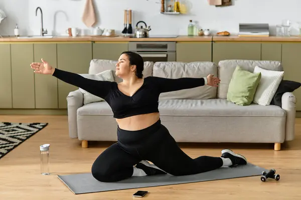 Uma bela jovem mulher plus size está desfrutando de uma rotina de alongamento em casa em uma acolhedora sala de estar — Fotografia de Stock