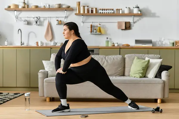 A young woman practices yoga in a bright, stylish living room. — Stock Photo