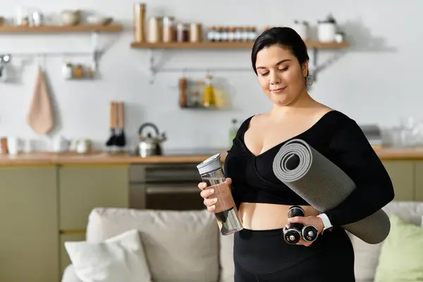 A young plus size woman preps for a workout in her bright, inviting home, showing her strength. — Stock Photo