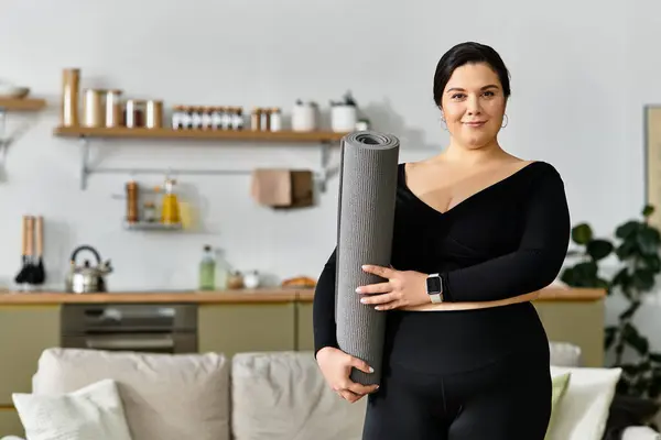 Uma jovem mulher confiante está pronta com um tapete de ioga em um ambiente doméstico elegante, abraçando o bem-estar. — Fotografia de Stock