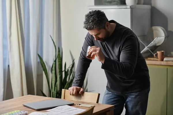 A handsome man enjoys a drink in a cozy, inviting kitchen. — Stock Photo