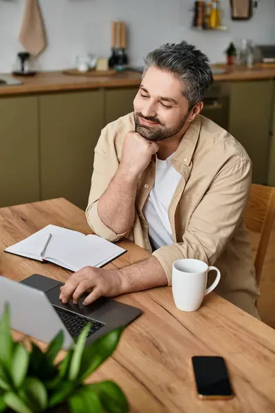 A thoughtful man enjoys a moment of inspiration while working in a modern kitchen. — Stock Photo
