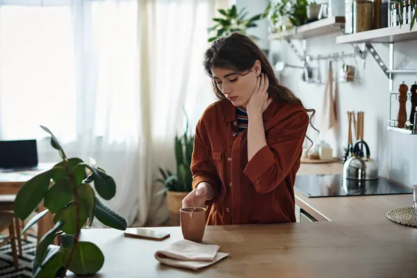 In a cozy kitchen filled with sunlight and greenery, a woman grapples with feelings of depression. — Stock Photo
