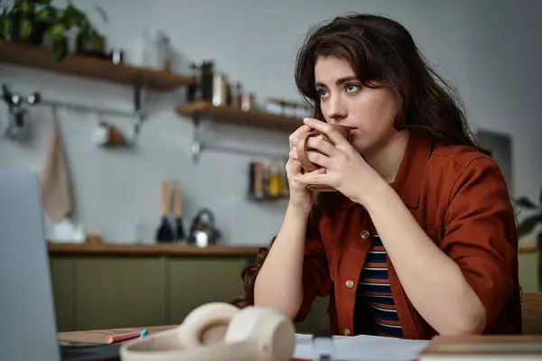 In a peaceful kitchen, a woman contemplates her emotions while holding a warm drink. — Stock Photo