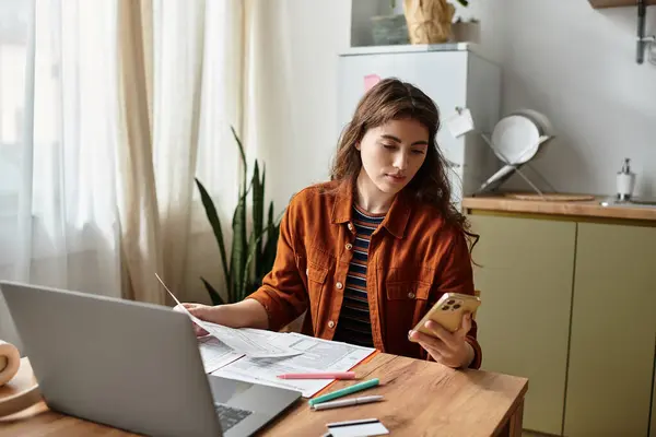 A woman with visible signs of distress navigates paperwork in her inviting home office. — Stockfoto