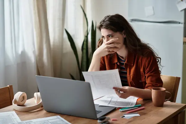A woman expresses her feelings of stress and sadness while working at a cluttered desk. — Stock Photo