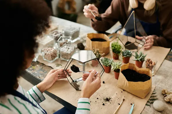 Les participants créent volontiers des terrariums remplis de plantes dans un atelier amusant. — Photo de stock