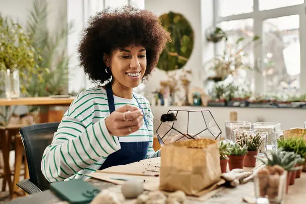 Un heureux participant crée un terrarium succulent dans un atelier végétal animé. — Stock Photo