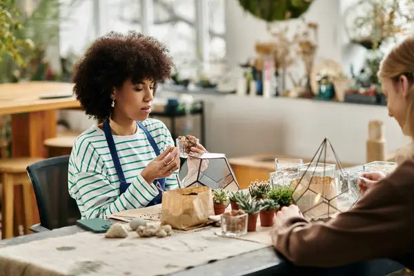 Amigos participan en un divertido taller, elaborando arreglos suculentos únicos juntos. - foto de stock