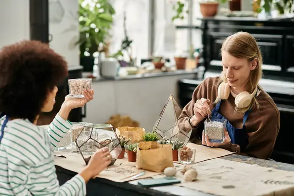 Two friends enjoying a lively workshop while crafting unique succulent arrangements. — Photo de stock