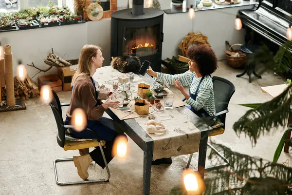Two friends happily create succulent arrangements at a vibrant workshop filled with greenery. — Stock Photo