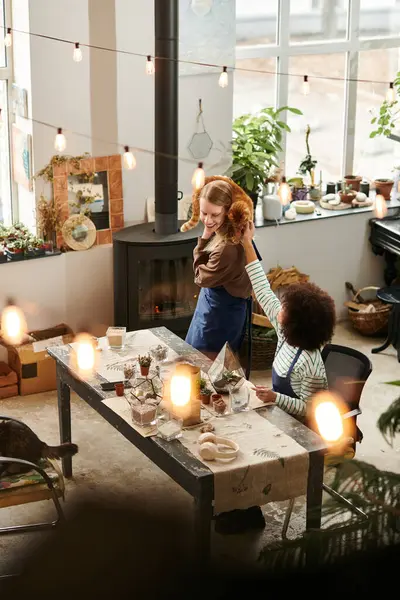 Participants at a lively workshop bond over crafting unique succulent arrangements in a cozy space. — Stock Photo