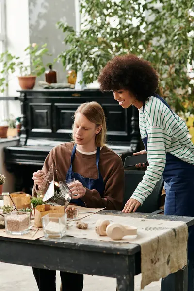 Los participantes exploran su creatividad a través de suculentos arreglos en un alegre entorno de taller. - foto de stock