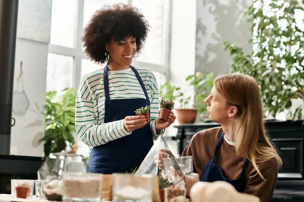 Two friends explore plant care techniques while surrounded by lush succulents and vibrant greenery. — Stock Photo