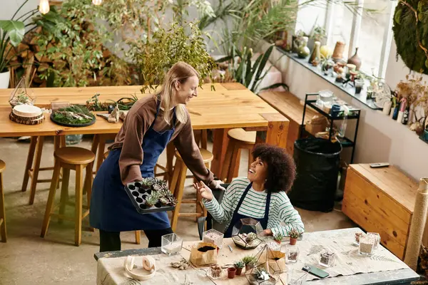 Two friends enjoy a lively workshop surrounded by vibrant succulents and beautiful plants. — Stockfoto