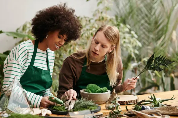 Two friends joyfully engage in a hands on workshop crafting with succulents and plants. — Stock Photo
