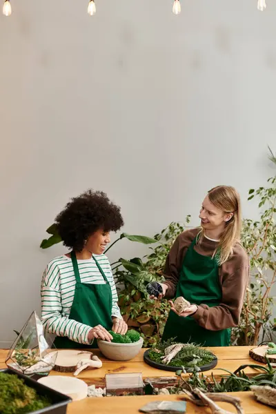 Two friends engaged in a joyful succulent workshop, surrounded by vibrant greenery and plants. — Stock Photo