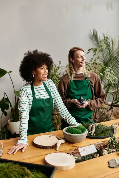 Two friends joyfully share creativity at a lively workshop full of plants and succulents. — Stock Photo