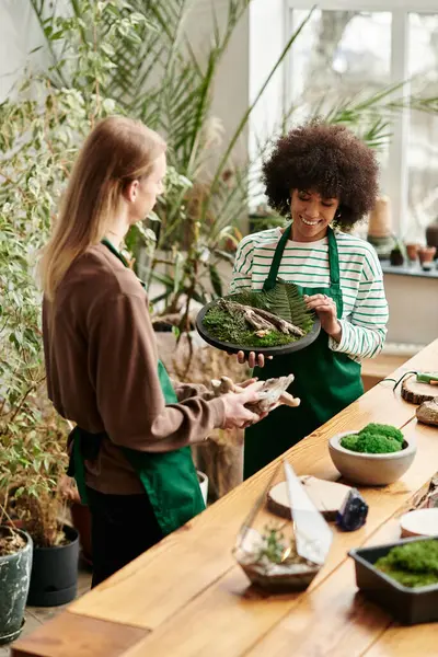 Participants engage in a lively workshop surrounded by lush plants and bright succulents. — Stock Photo