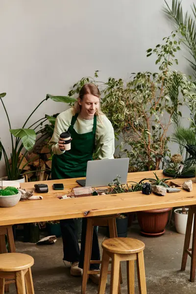 Handsome man working with his laptop in a vibrant green setting. — Stock Photo