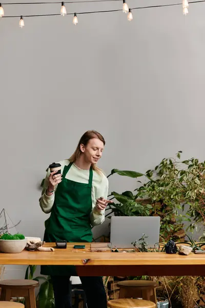 Stylish man working with his laptop in a vibrant green setting. — Foto stock