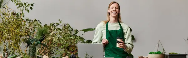 Handsome man in green apron working in a vibrant green setting. — Stock Photo