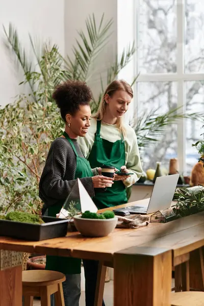 Two friends share laughter and creativity while working with succulents in a bright workshop space. — Stock Photo