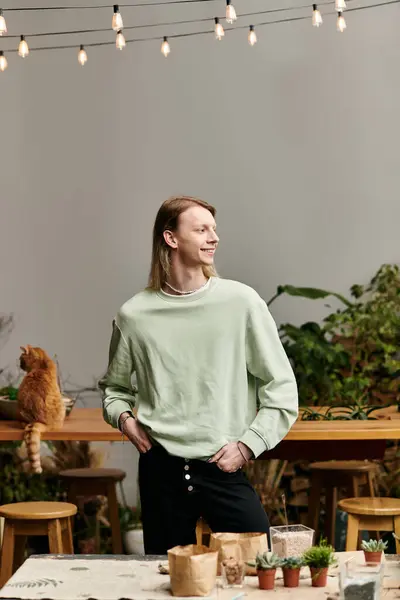 Joyous long haired man in stylish attire in workshop studio. — Stock Photo