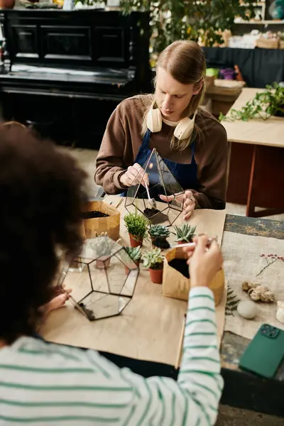 Engaging in a creative workshop, friends are crafting beautiful terrariums filled with succulents. — Stock Photo