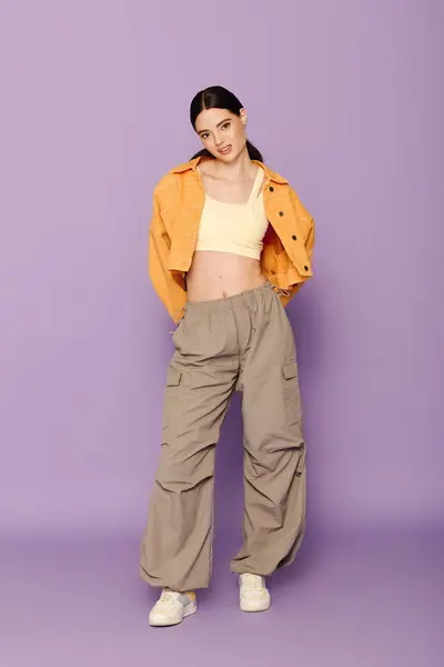 Young woman shows off trendy outfit featuring cargo pants and a cropped top, radiating confidence. — Stock Photo