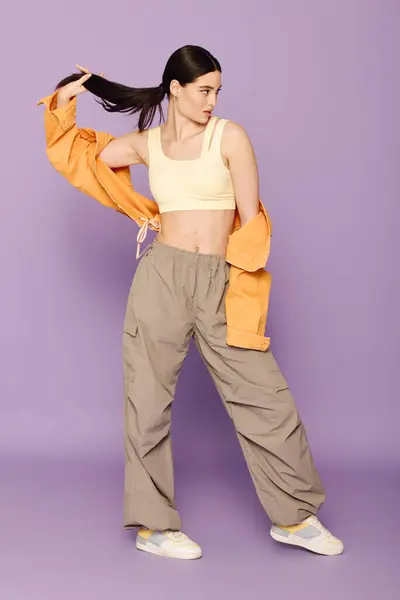 A stylish young woman poses confidently, showcasing her trendy outfit and flair. — Stock Photo