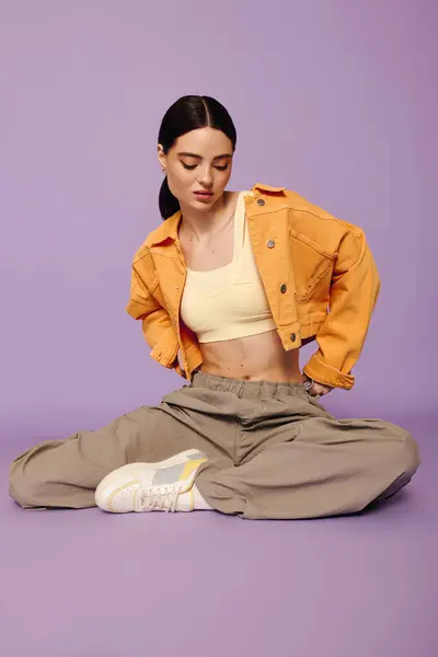 A fashionable young woman exudes confidence while seated comfortably, showcasing her standout look. — Stock Photo
