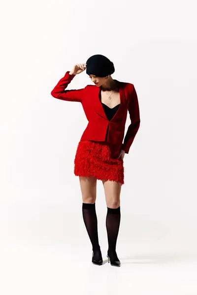 A fashionable young woman showcases her stylish look in a vibrant red ensemble, striking a pose. — Stock Photo