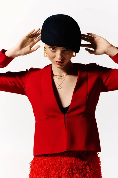 A beautiful young woman showcases her fashion sense with a striking red ensemble and a stylish hat. — Stock Photo