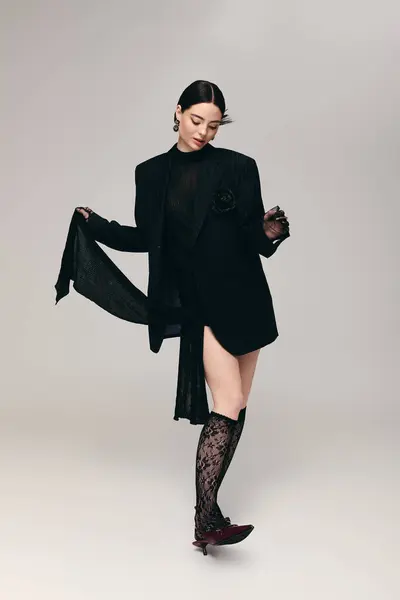 A young woman poses confidently in a striking black outfit, exuding style and grace. — Stock Photo
