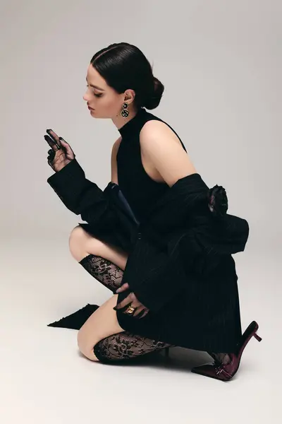 Young woman in chic attire poses gracefully, capturing elegance with poised expression and style. — Stock Photo