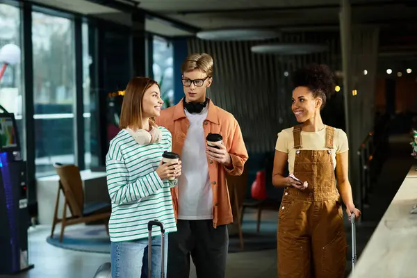 Colleghi impegnarsi in una conversazione amichevole, mentre tenendo tazze di caffè nella hall dell'hotel. — Foto stock