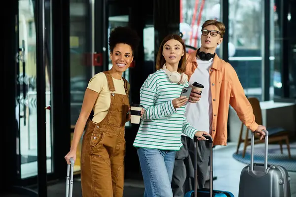 Tres colegas sonríen y están listos para su aventura al llegar al hotel. - foto de stock