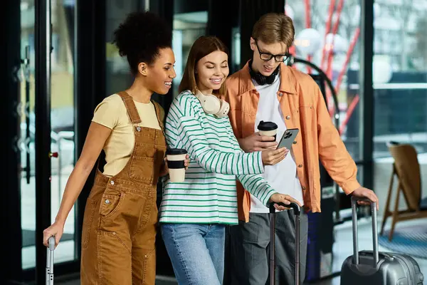 Three colleagues relax in a hotel lobby, sharing a laugh while checking their phones. — Stock Photo