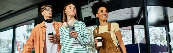 Três colegas estão envolvidos em uma conversa animada enquanto seguram xícaras de café em um lobby do hotel. — Fotografia de Stock